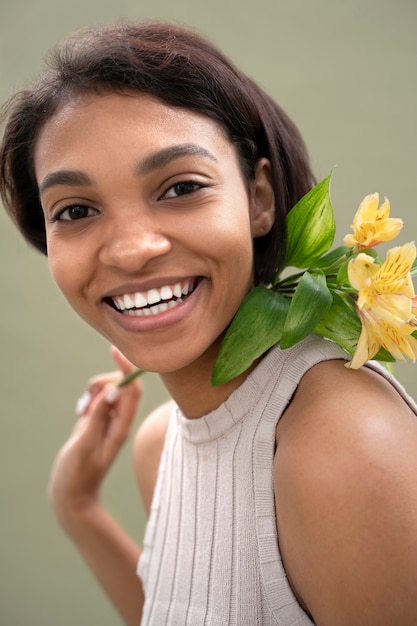 Smiley woman holding flower close up