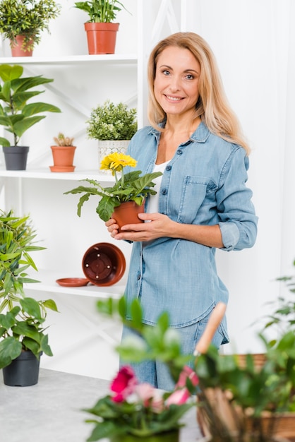 植木鉢を保持しているスマイリー女性