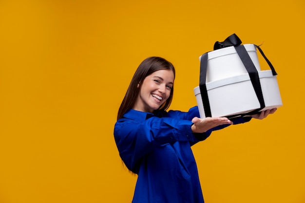 Smiley woman holding gift boxes medium shot