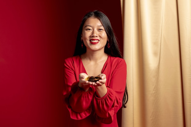 Smiley woman holding golden confetti in hands