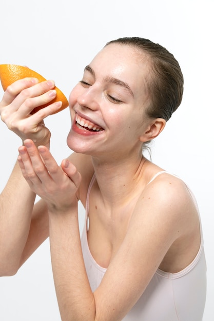 Улыбающаяся женщина с грейпфрутом, вид сбоку