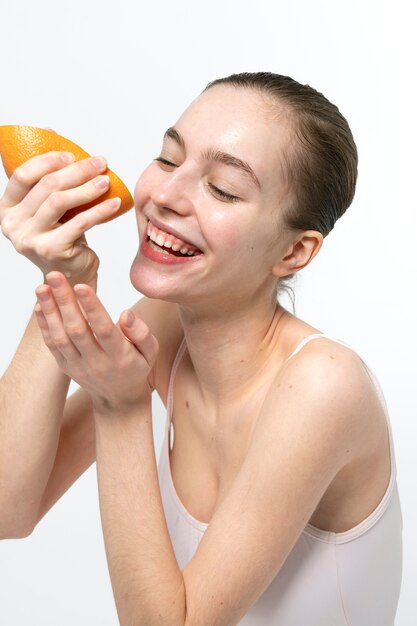 Улыбающаяся женщина с грейпфрутом, вид сбоку