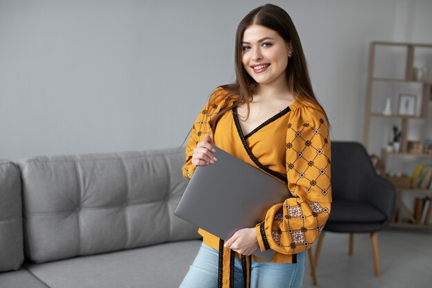 Free photo smiley woman holding laptop medium shot