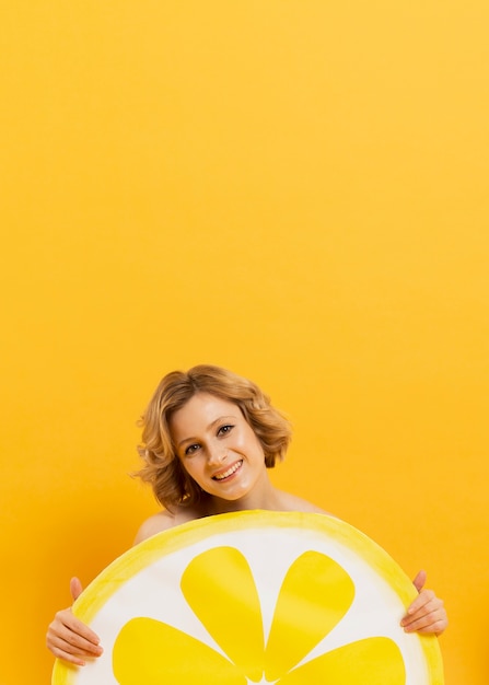 Smiley woman holding lemon slice