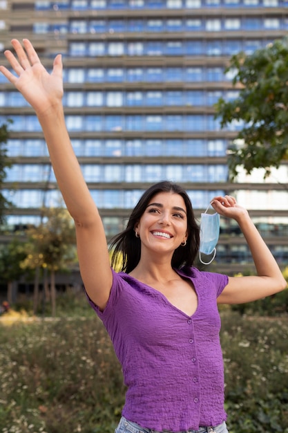 Free photo smiley woman holding mask front view