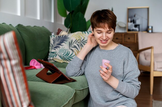 Smiley woman holding menstrual cup medium shot