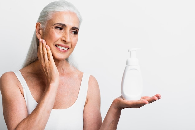 Free photo smiley woman holding moisturizer