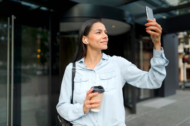 電話ミディアムショットを保持しているスマイリー女性