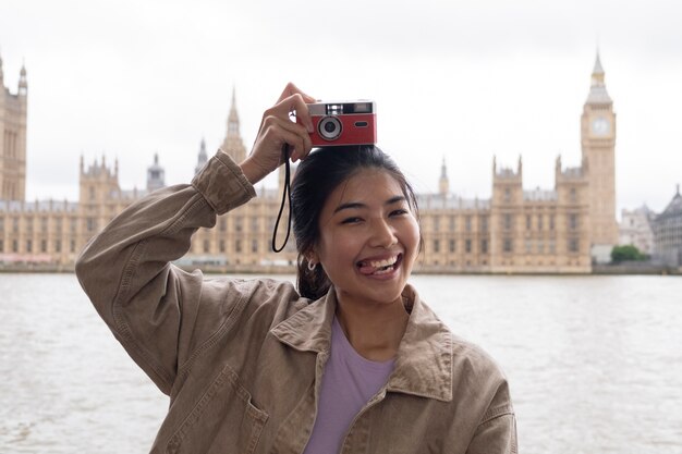 Smiley woman holding photo camera medium shot