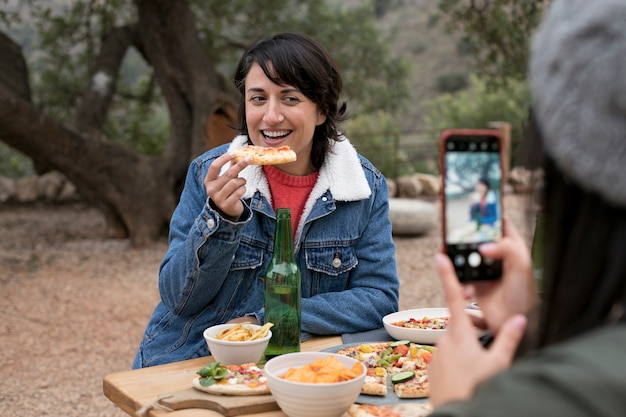 Foto gratuita fetta di pizza della holding della donna di smiley