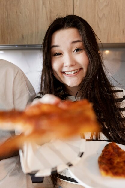 Smiley woman holding pizza slice