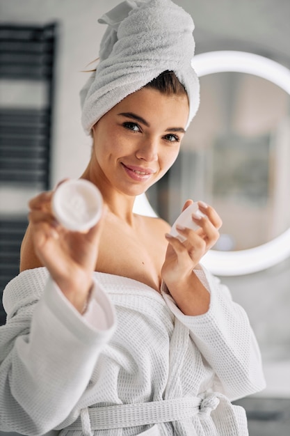 Free photo smiley woman holding a skincare cream