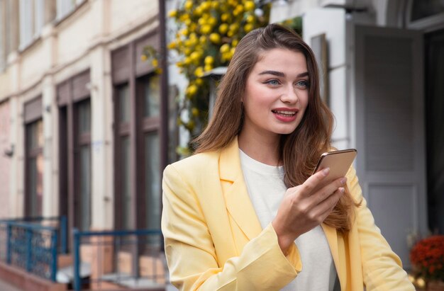 Smiley woman holding smartphone while being on a bike