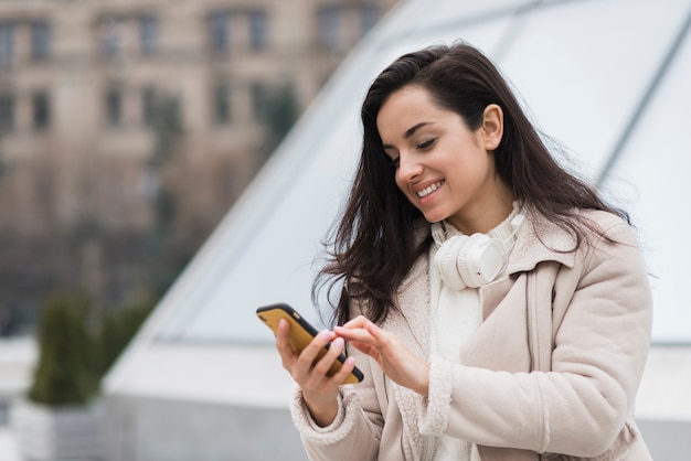 Smiley woman holding smartphone