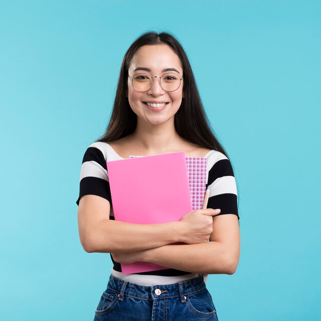 Smiley woman holding stack of books