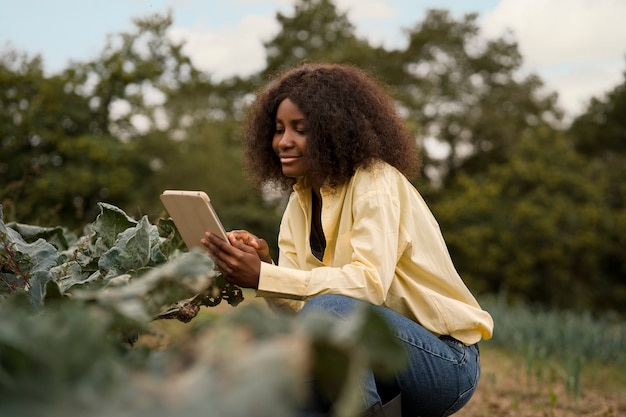 Free photo smiley woman holding tablet full shot