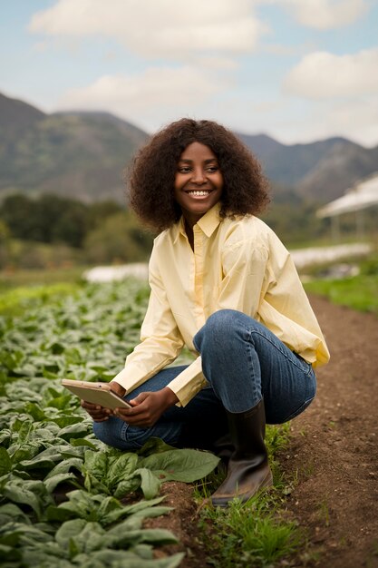 Free photo smiley woman holding tablet full shot