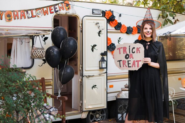 Smiley woman holding trick or treat sign