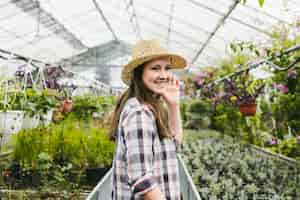 Free photo smiley woman inside greenhouse