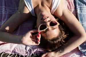 Free photo smiley woman laying on beach top view