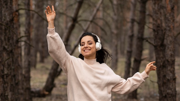 Foto gratuita musica d'ascolto della donna di smiley alle cuffie