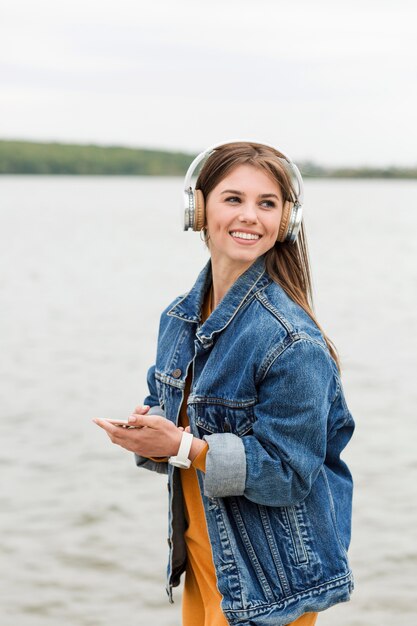 海辺で音楽を聴くスマイリー女性