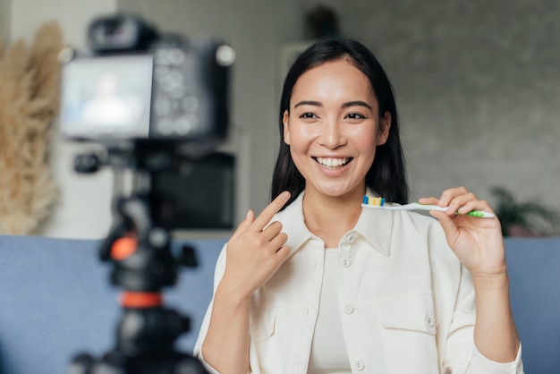 Smiley woman live streaming about dental problems