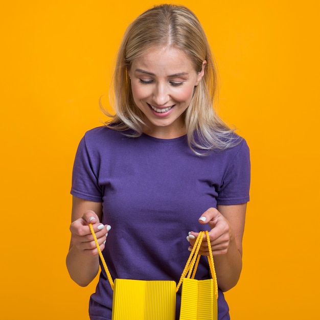 Foto gratuita donna sorridente che esamina le sue borse della spesa