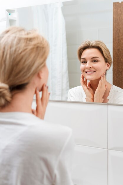 Smiley woman looking in the mirror