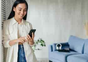 Free photo smiley woman looking at the phone with copy space