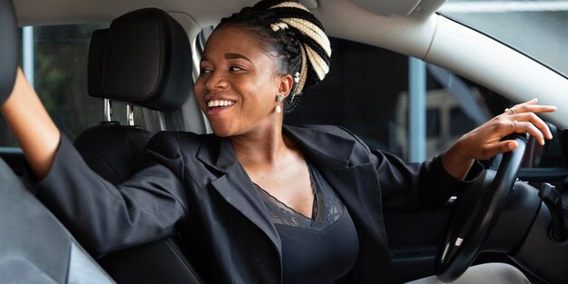 Smiley woman looking behind while backing her car off