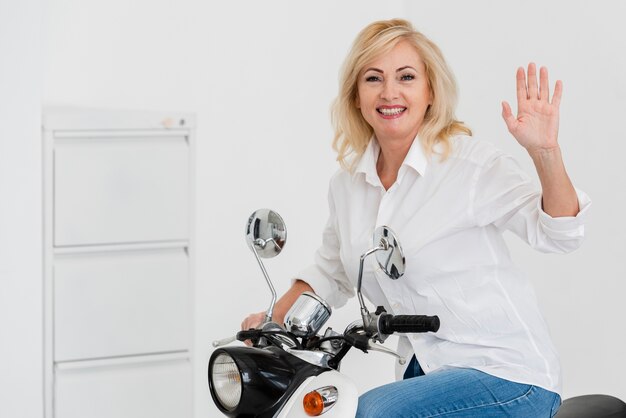 Free photo smiley woman on motorcycle