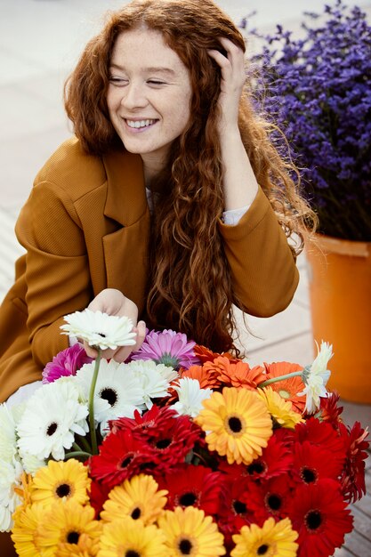 Смайлик женщина на открытом воздухе весной с букетом цветов