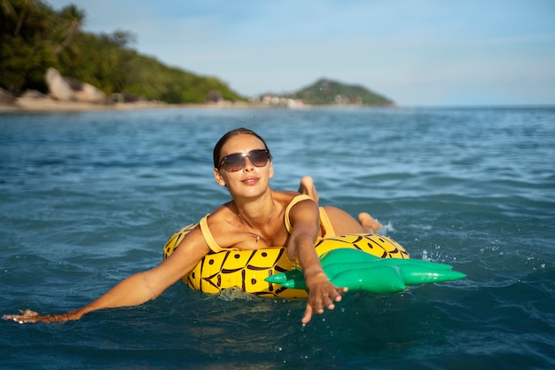 Smiley woman on pineapple floater side view