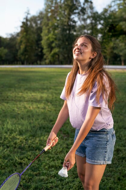 Smiley woman playing badminton side view