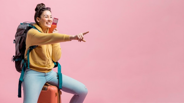 Smiley woman pointing in front of her with copy space