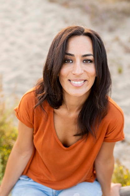 Foto gratuita donna di smiley che propone dalla spiaggia