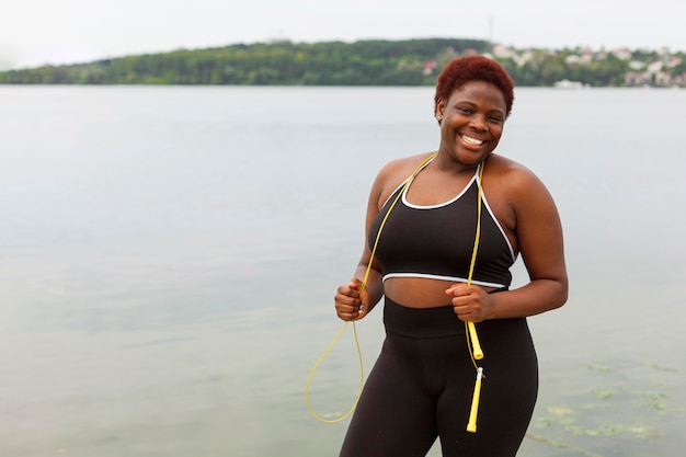 Smiley woman posing by the beach