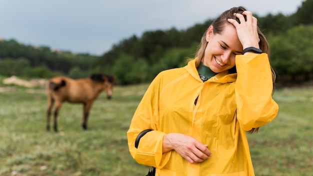 Smiley woman posing next to a horse