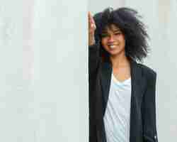 Free photo smiley woman posing near wall