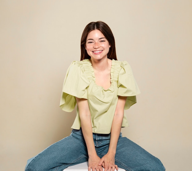 Free photo smiley woman posing and sitting