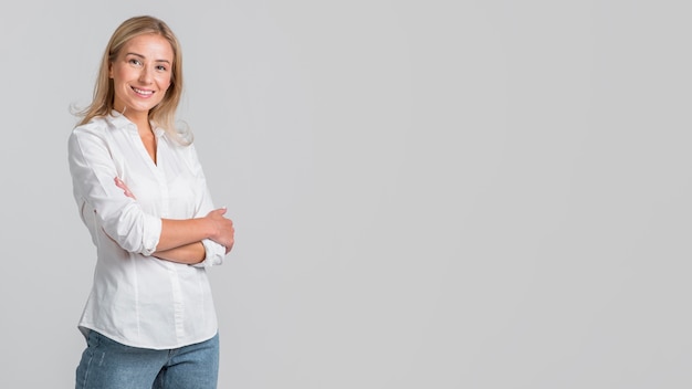 Smiley woman posing with arms crossed and copy space