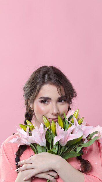 Smiley woman posing with bouquet of lilies