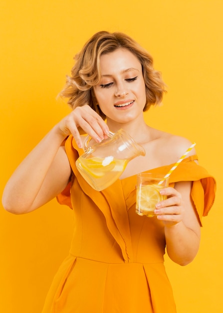 Free photo smiley woman pouring lemonade