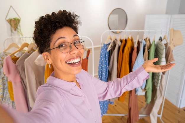 Smiley woman presenting clothes side view