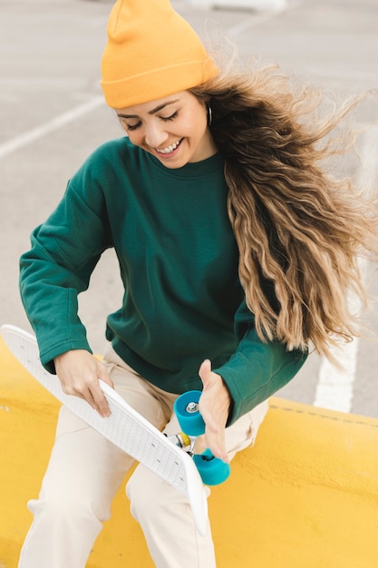 Smiley woman rolling skateboard wheels