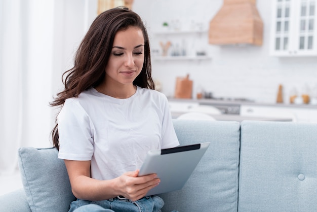 Smiley woman scrolling the internet on her tablet