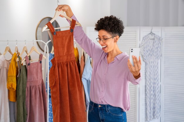 Smiley woman selling clothes medium shot