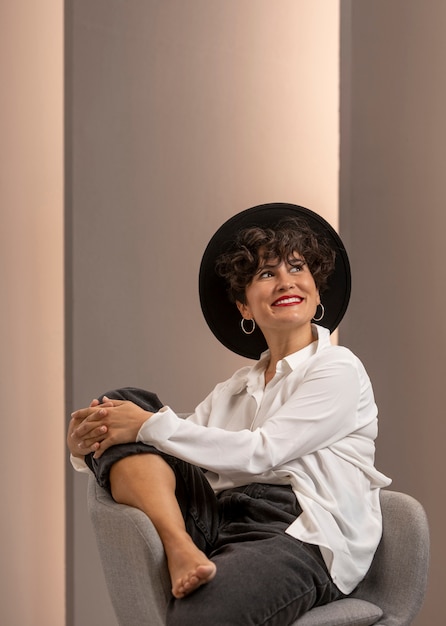 Free photo smiley woman sitting on chair medium shot