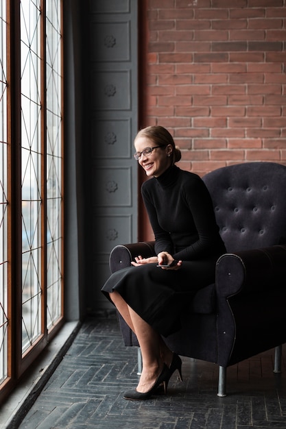 Free photo smiley woman sitting on couch